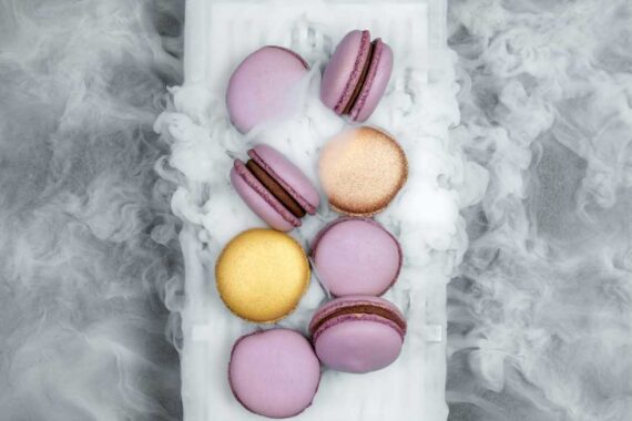 A plate of macarons surrounded by decorative dry ice