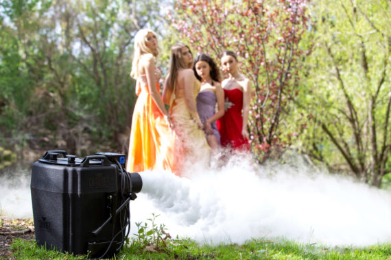 Four young women are posing in front of a dry ice fog machine