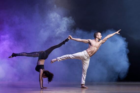 two contemporary dancers are on stage. The stage is filled with fog from a dry ice fog machine