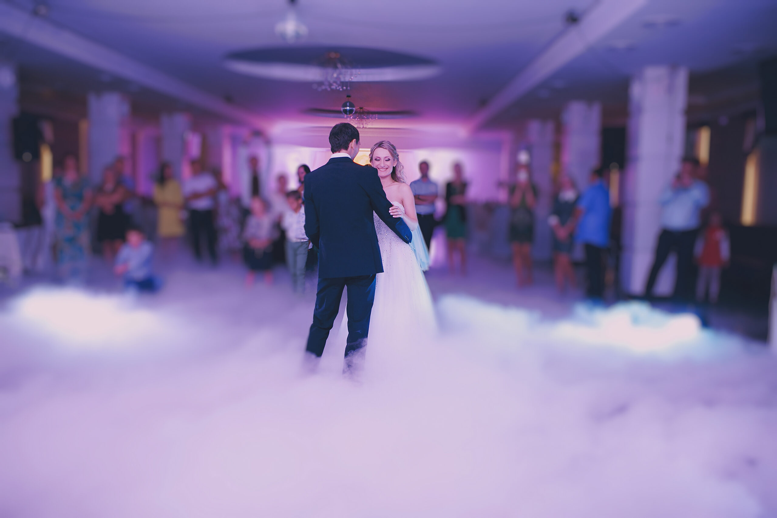 A bride & groom dance in fog from a dry ice fog machine on dancefloor